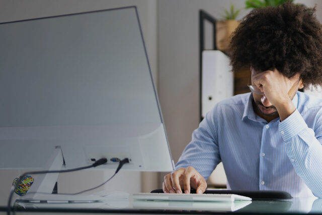 Frustrated man working on computer